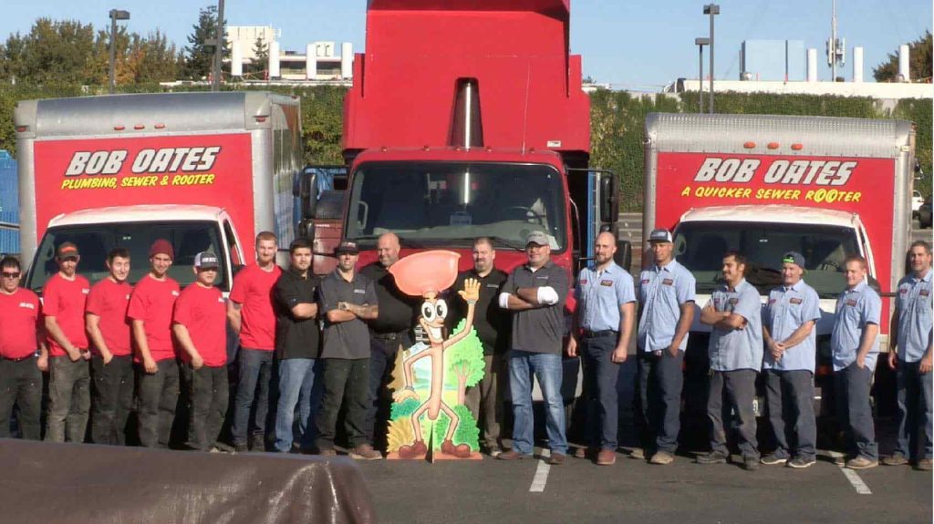 Group photo of of Bob Oates technicians standing in front of company trucks