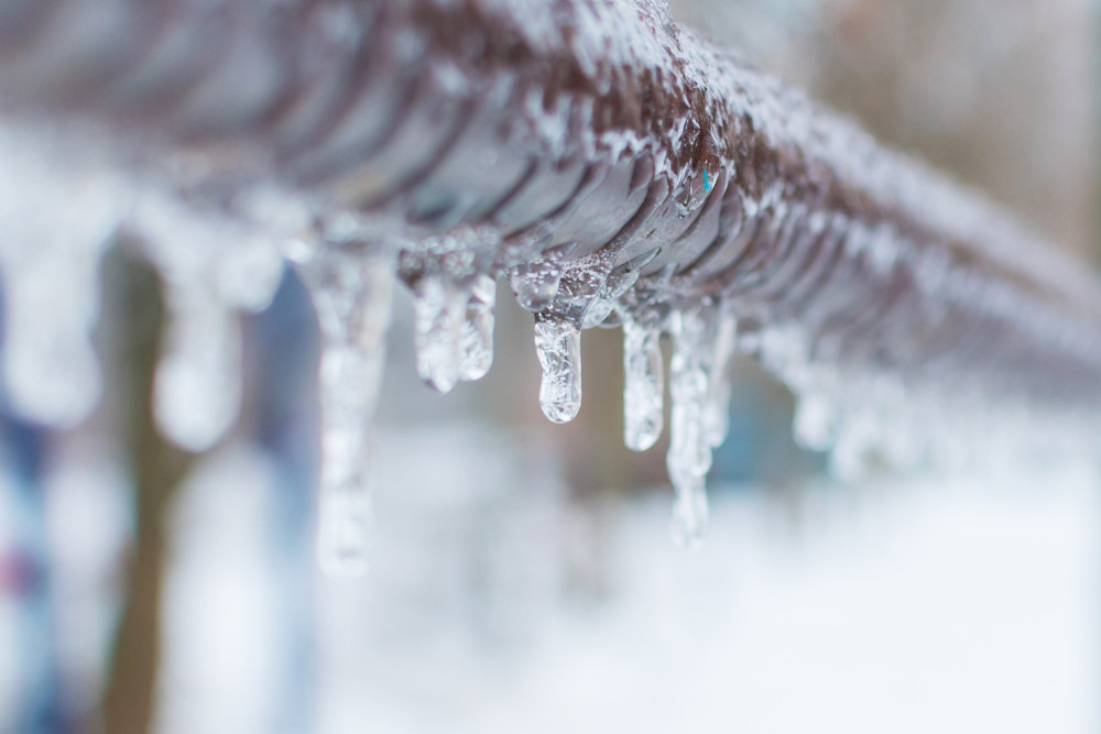 Frozen icicles after rain elevated pipe