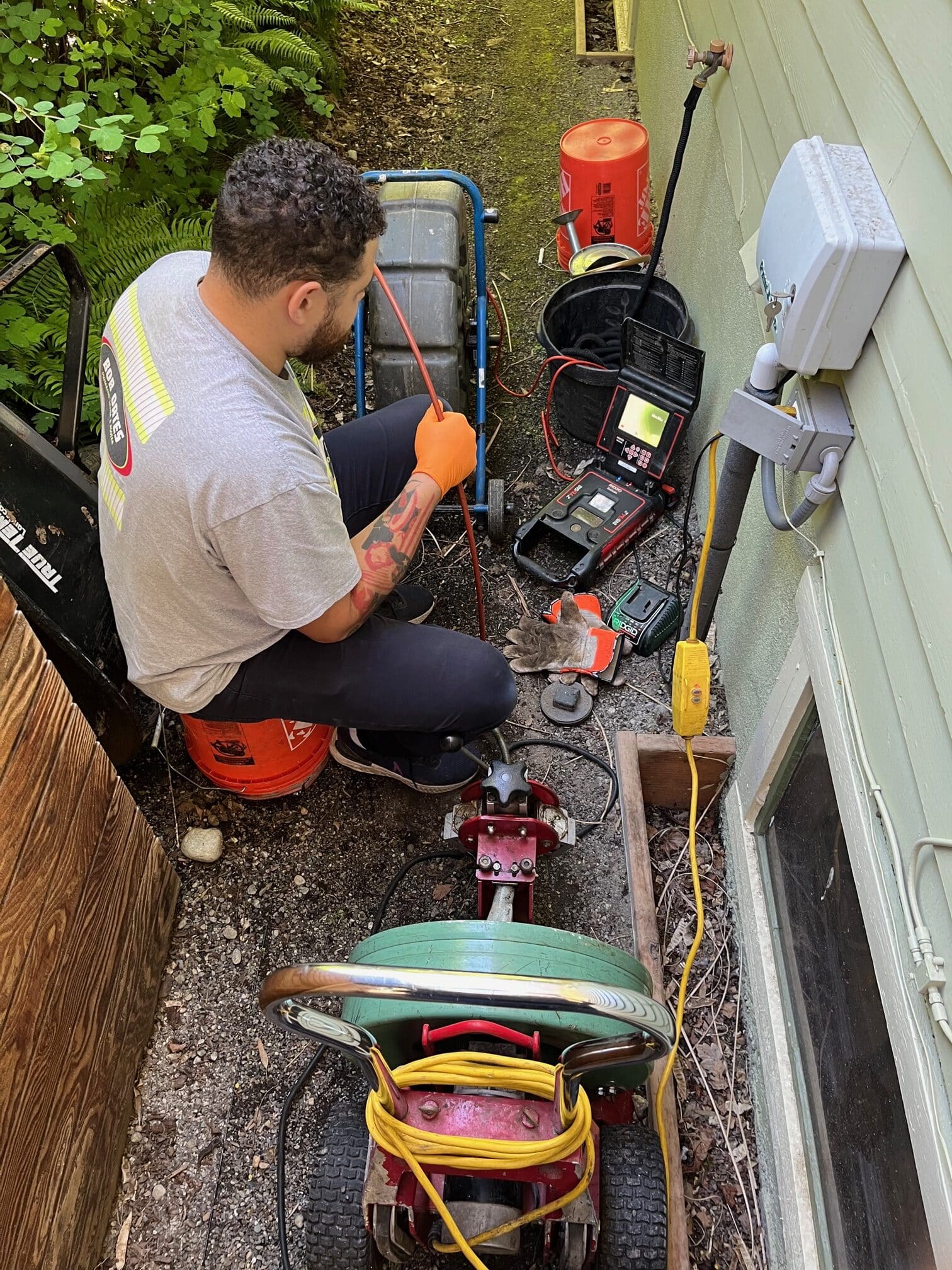 Bob Oates technician holding the camera feed and watching the monitor while performing a video sewer inspection.