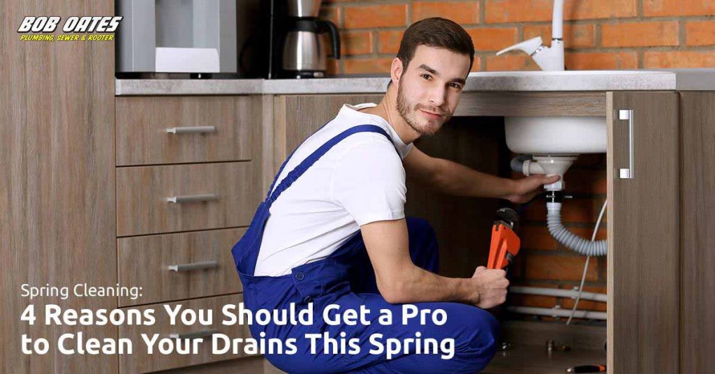 Man in trousers working on plumbing pipes under the sink