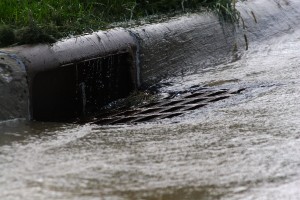 City storm drain with water draining into it