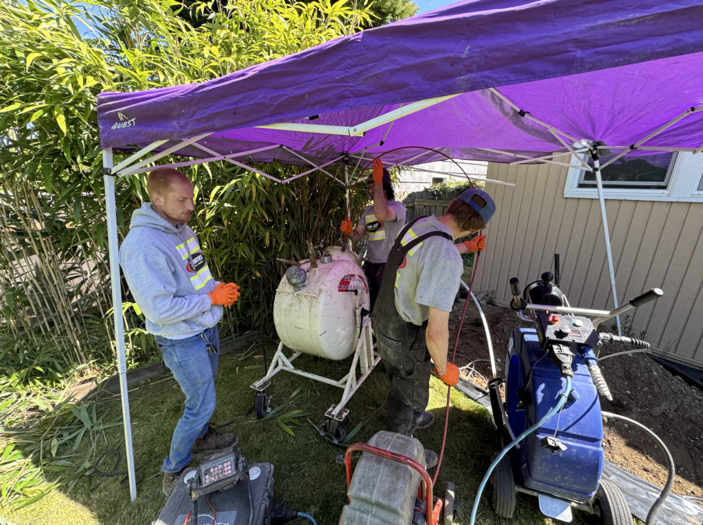 Image of Bob Oates techs using 70’ of liner, called blue light cure in trenchless sewer repair, for a sewer relining job.