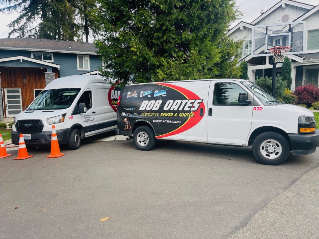 Bob Oates Plumbing, Sewer & Rooter trucks parked at a residential service call in Seattle