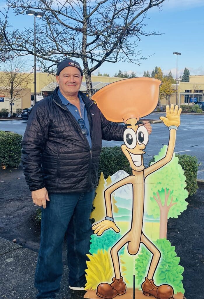 Bob Oates standing next to company mascot Poopy the Plunger in Seattle
