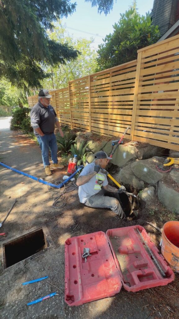 Bob Oates technician locating the water service connection during a residential water line replacement in Seattle