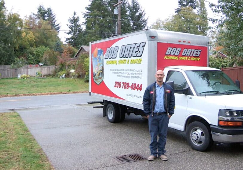 Bob Oates Plumbing technician standing beside a service truck during a residential plumbing and sewer service call in Seattle