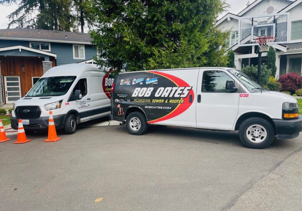 Bob Oates Plumbing, Sewer & Rooter trucks parked at a residential service call in Seattle