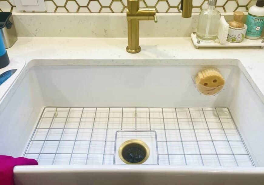 Modern white kitchen sink with brass faucet and clean countertop