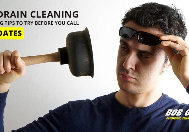 Man holding plunger and unsure what to do next