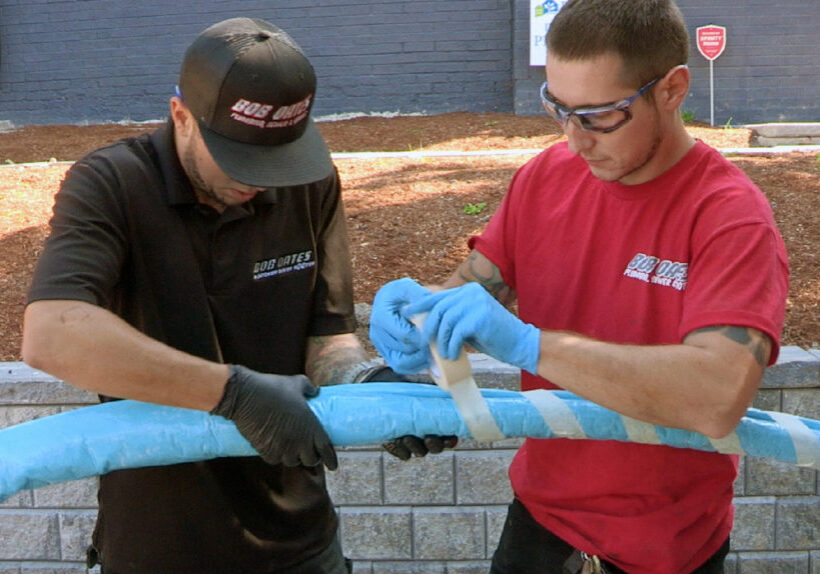 Bob Oates technicians preparing a blue CIPP liner for trenchless sewer repair.